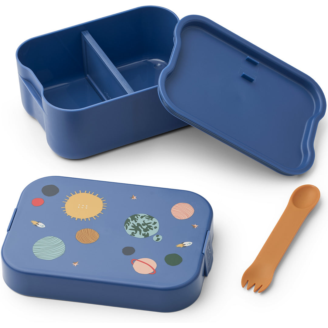 Liewood blauwe kinderbroodtrommel met universumthema, open met deksel ernaast en een oranje spork.