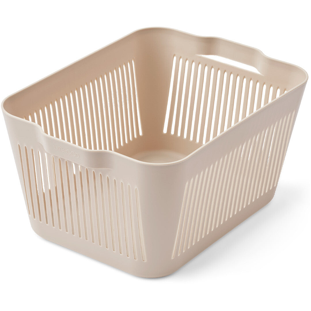 Een enkele beige Liewood opbergbak met verticale sleuven, schuin van bovenaf gefotografeerd.