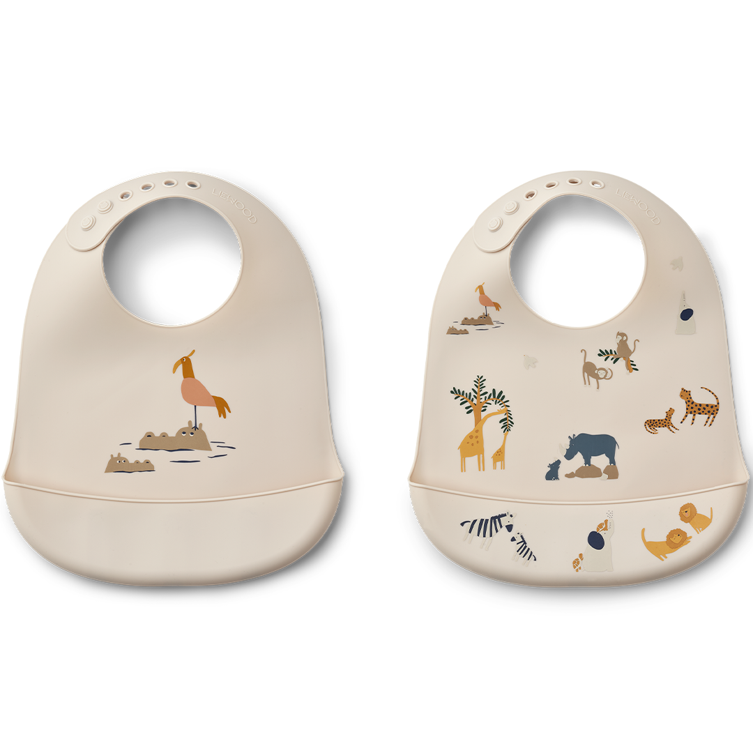 Twee Liewood siliconen babyslabbetjes met dierenprint, één met een vogel en de ander met diverse safari dieren.