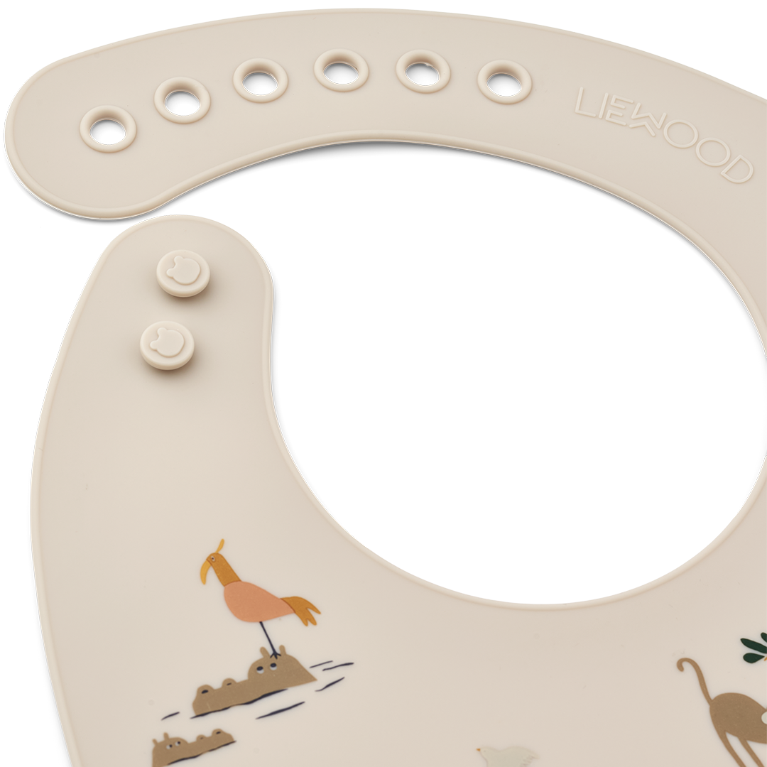 Detail van een Liewood siliconen babyslabbetje met het merklogo en een deel van de vogelprint.