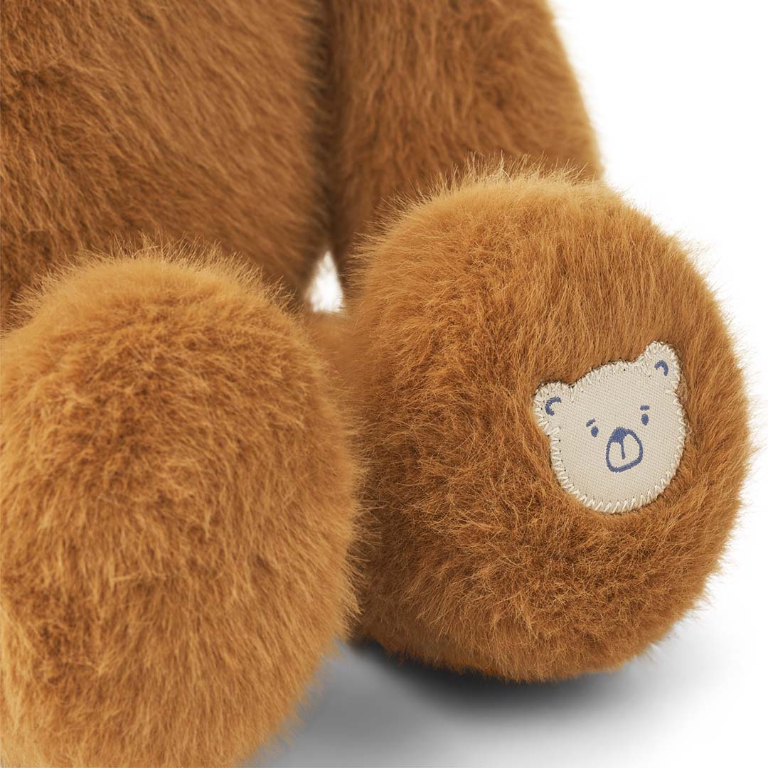 Detail van de poot van de Liewood pluchen teddybeer Berto, met een wit geborduurd beertje.