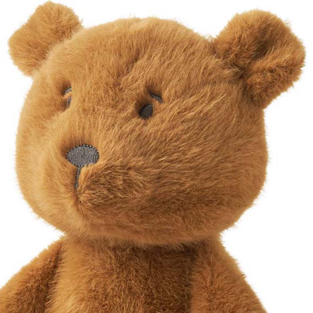 Close-up van het gezicht van de Liewood pluchen teddybeer Berto in golden caramel kleur.