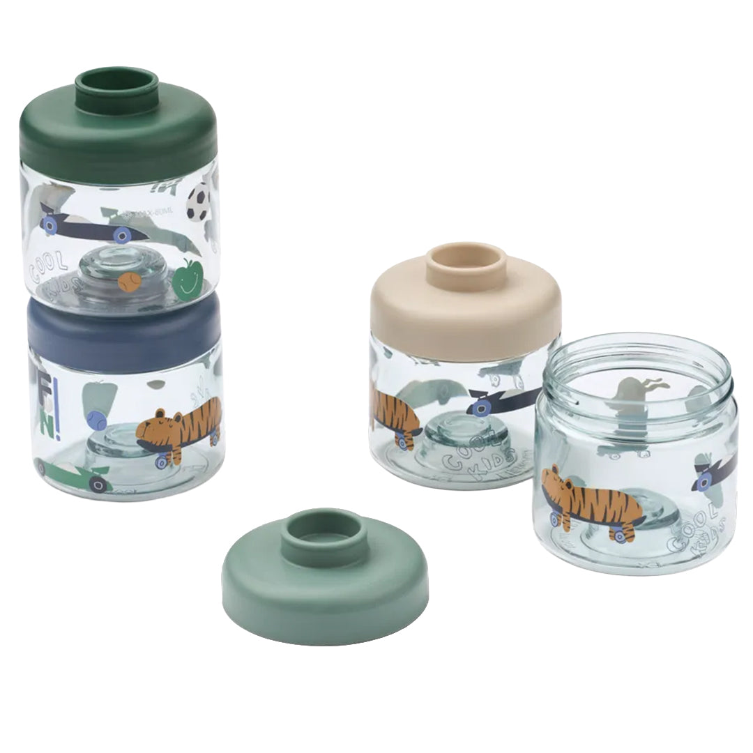 Collectie Liewood babyvoeding doosjes met patronen van dieren, voertuigen en tekst, waarvan twee gestapeld en één open.