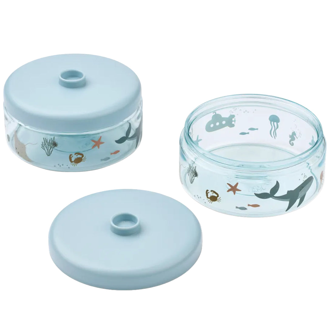 Twee Liewood babyvoeding doosjes met zeedieren en onderzeeër patroon, waarvan één open en één gesloten.