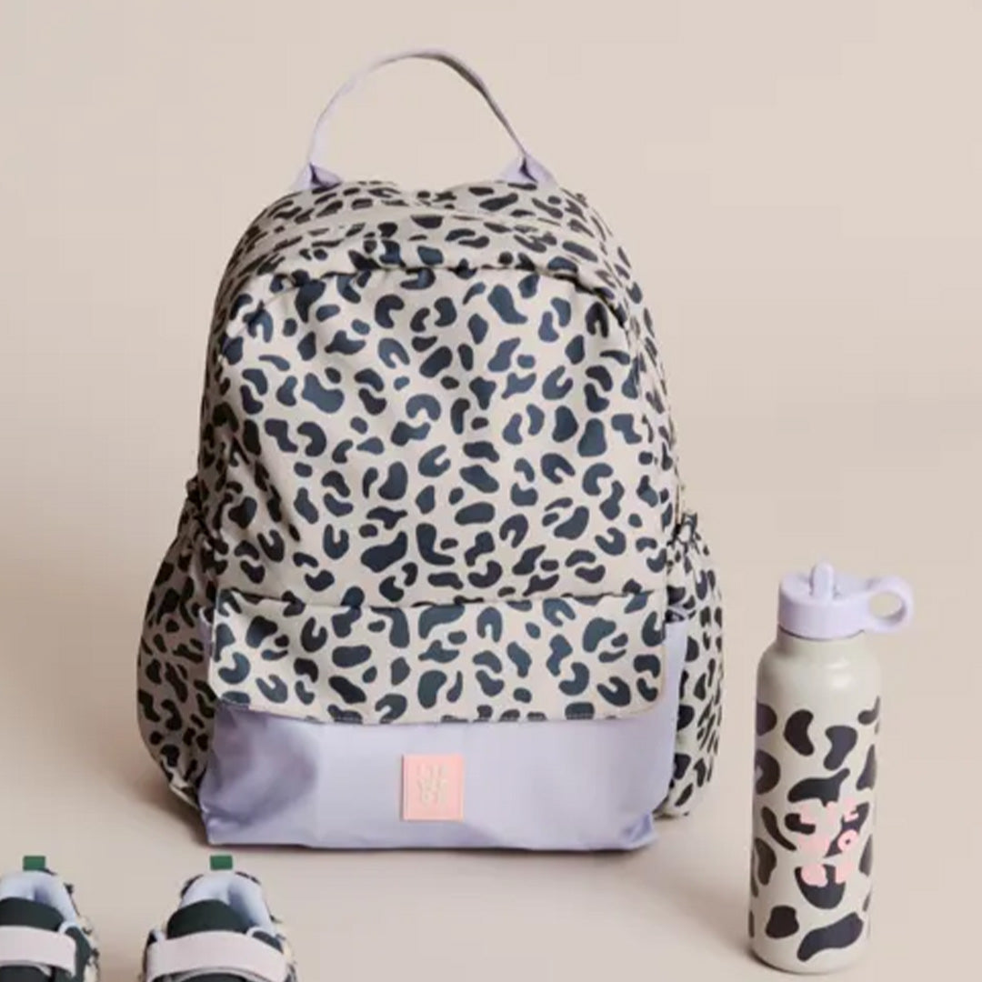 Liewood kinderrugtas Lennon met luipaardprint, staand naast een bijpassende waterfles en schoenen.
