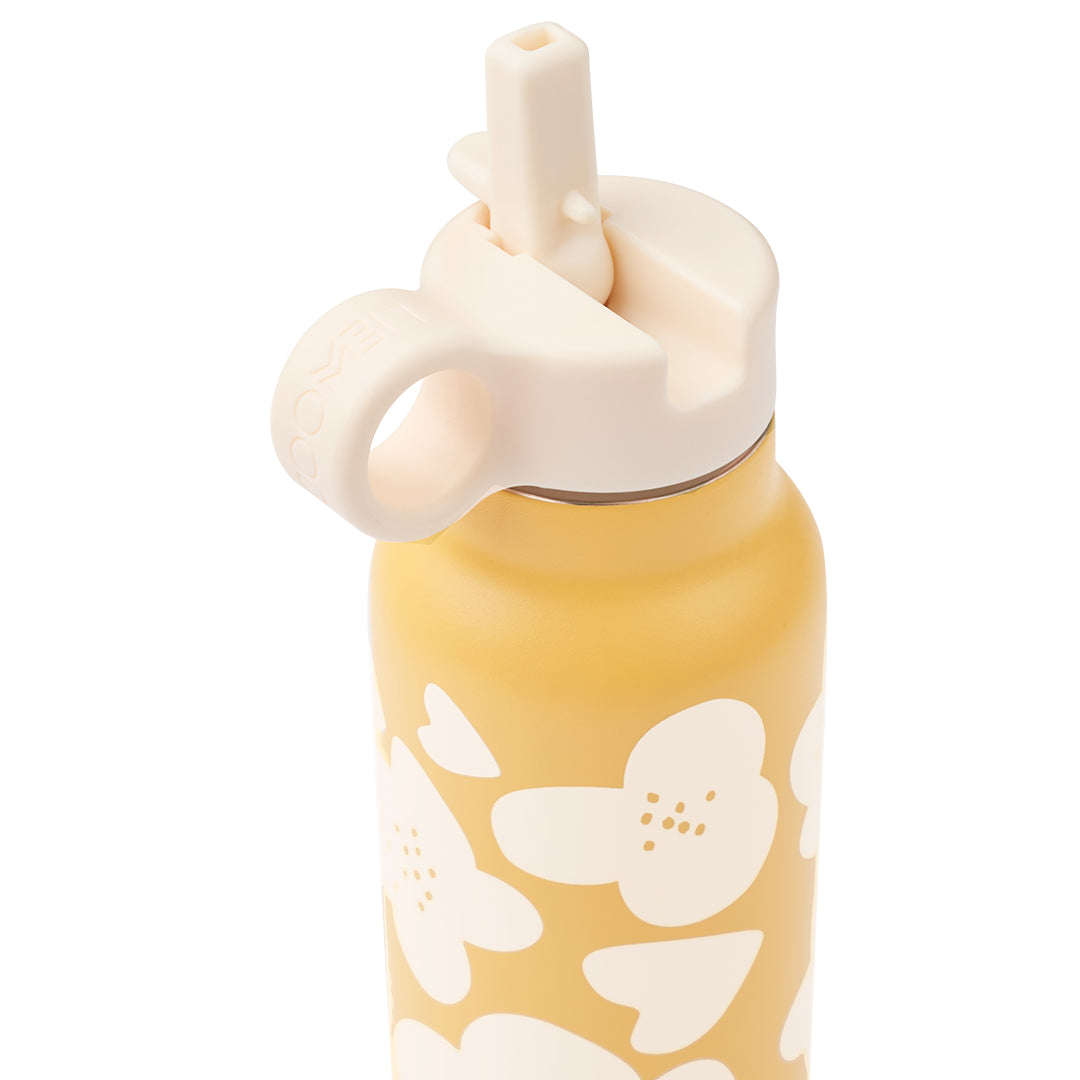 Detail van de bovenkant van een Liewood gele thermosfles met bloemenpatroon en een beige uitklapbare drinktuit.