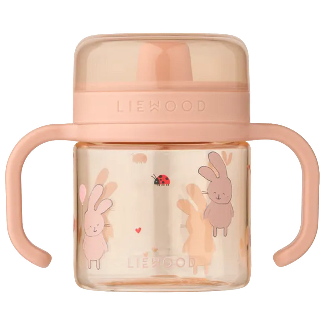 Liewood roze tuitbeker met handvatten en een patroon van konijnen en een lieveheersbeestje.
