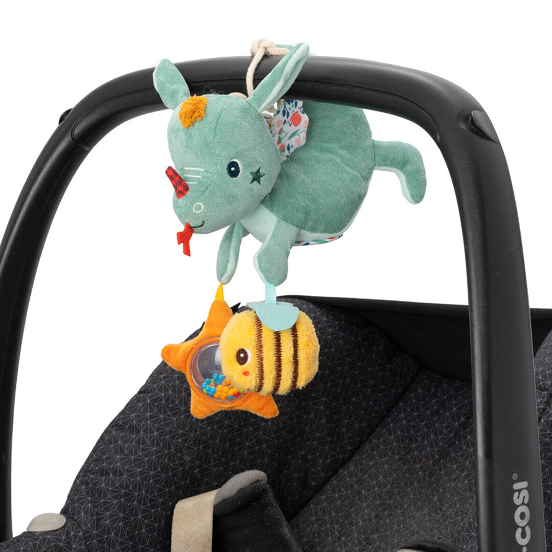 Lilliputiens groene draak activiteitenhanger bevestigd aan de beugel van een autostoel.