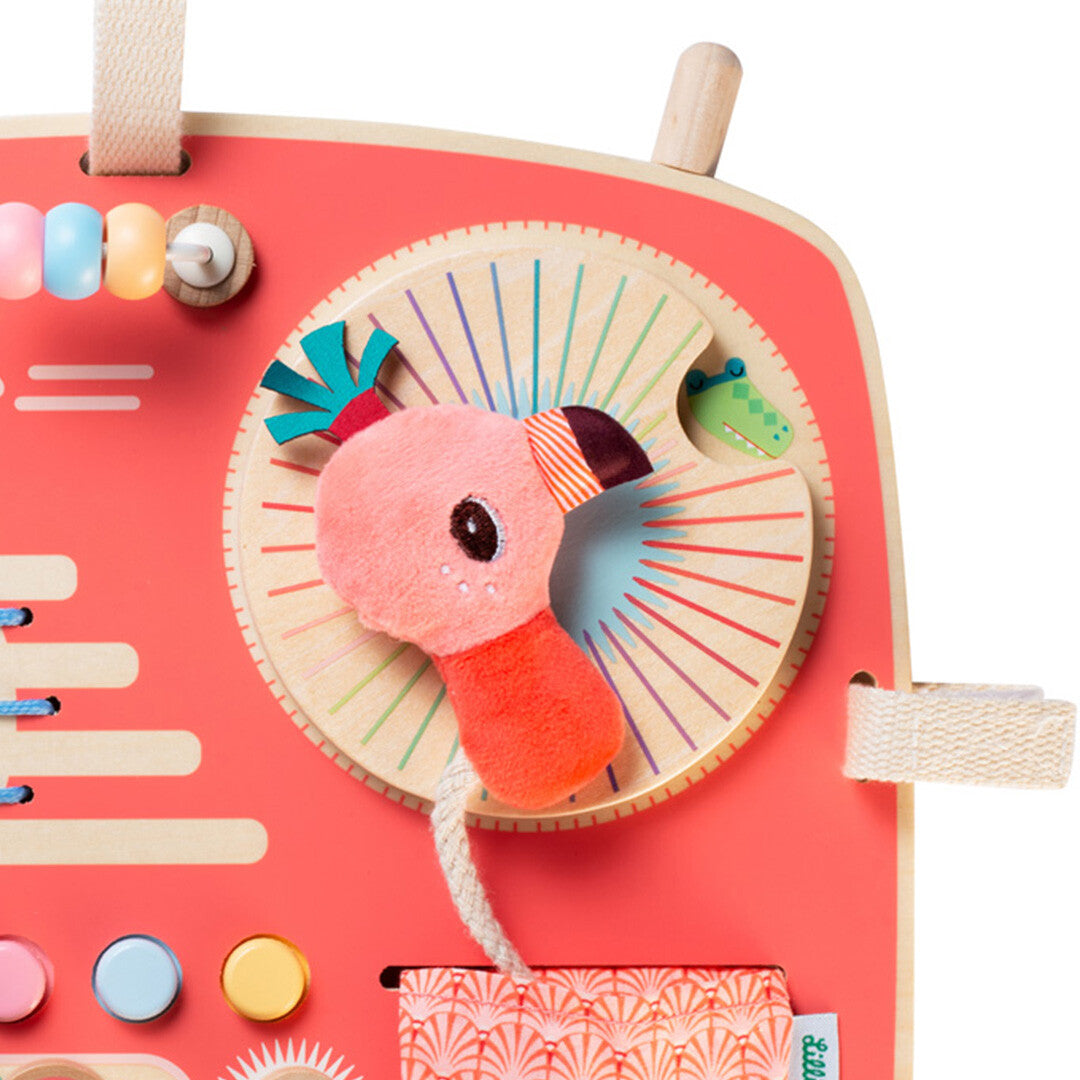 Detail van het Lilliputiens activiteitenpaneel met de roze flamingo en een draaischijf.