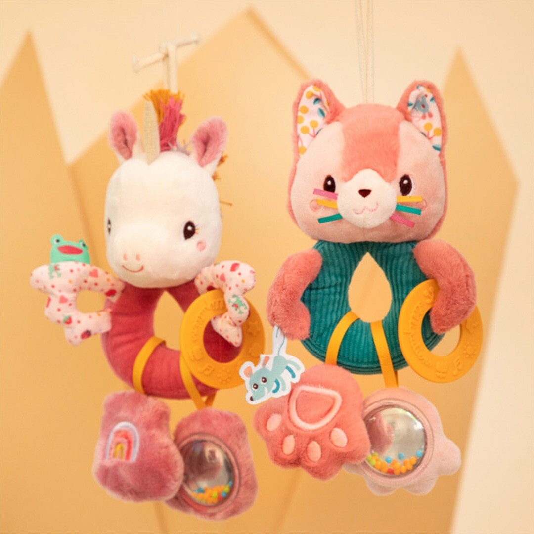 Twee Lilliputiens activiteitenringen voor baby's, een roze eenhoorn en een roze kat, hangen naast elkaar.