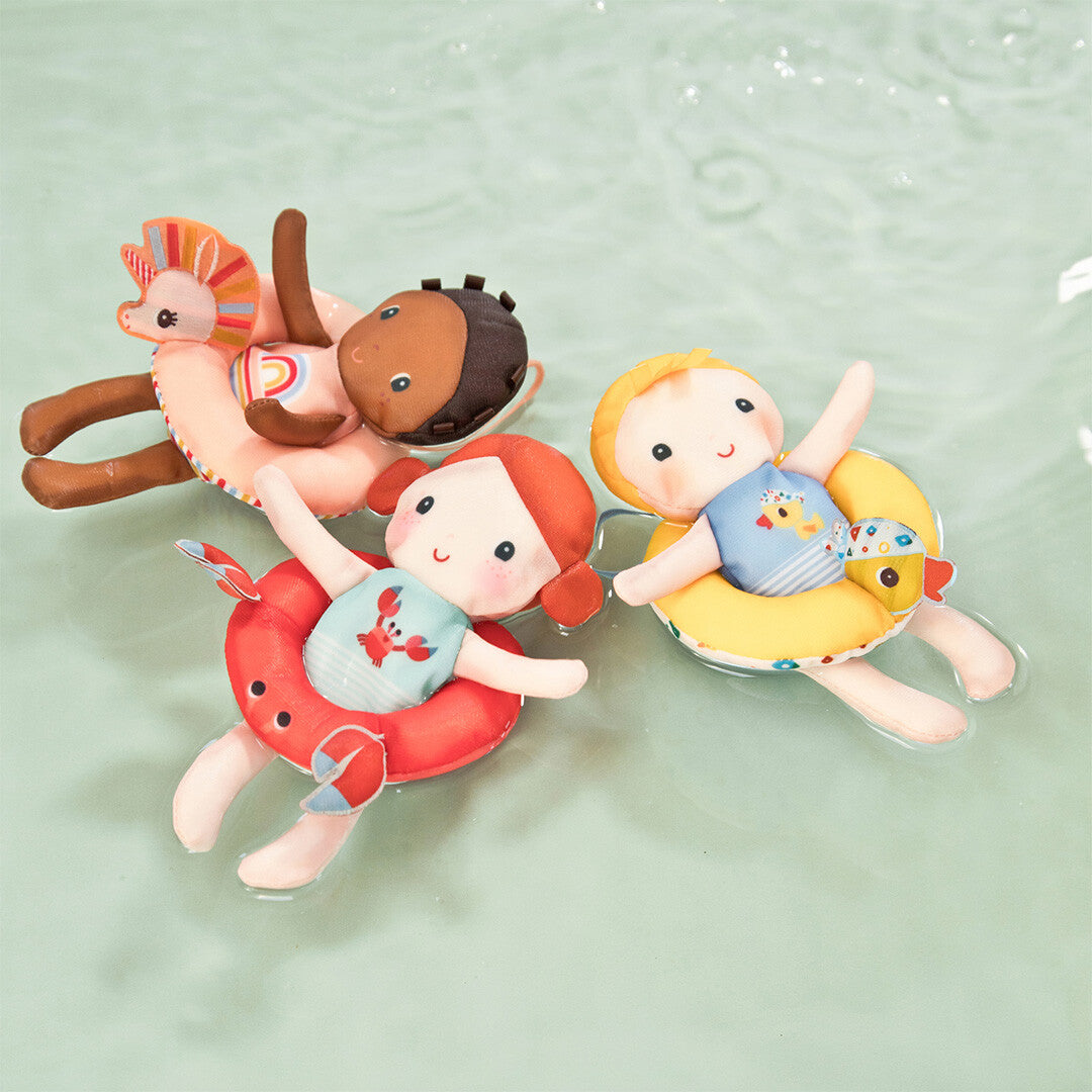 Drie Lilliputiens badpoppen met verschillende zwembanden drijven in het water.