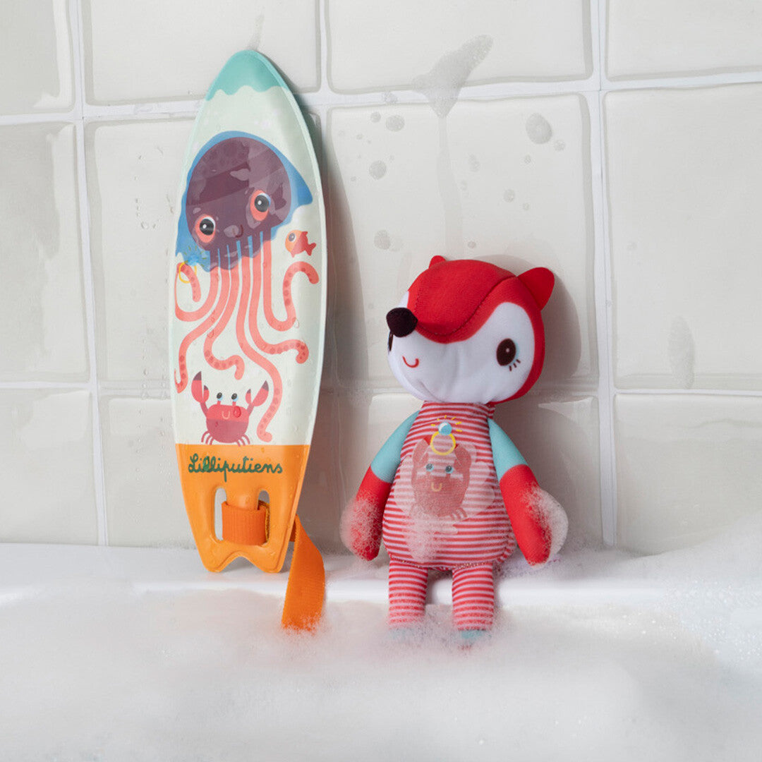De Lilliputiens vossenpop en het surfboard met octopus drijven in een bad met schuim.
