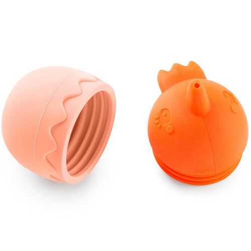 Het Lilliputiens badspeeltje, een oranje kuiken en roze eierschaal, ligt in twee losse delen.
