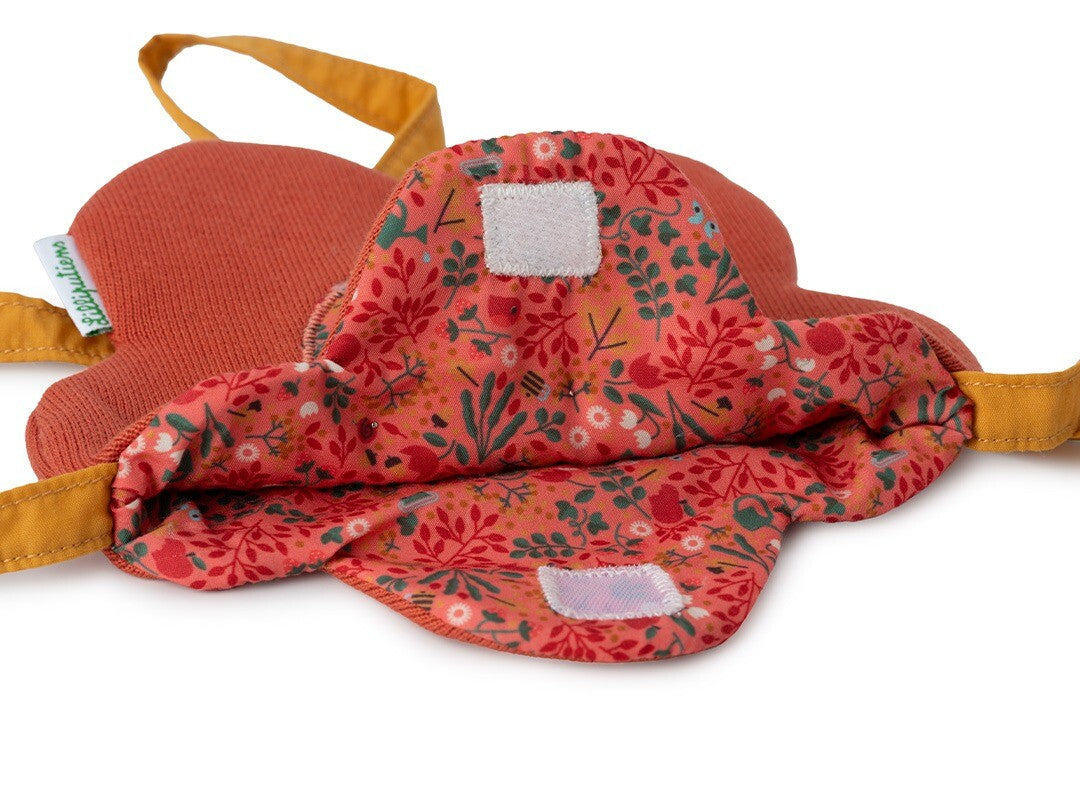 Detail van de open rode bloemvormige kindertas met gebloemde voering en klittenbandsluitingen.
