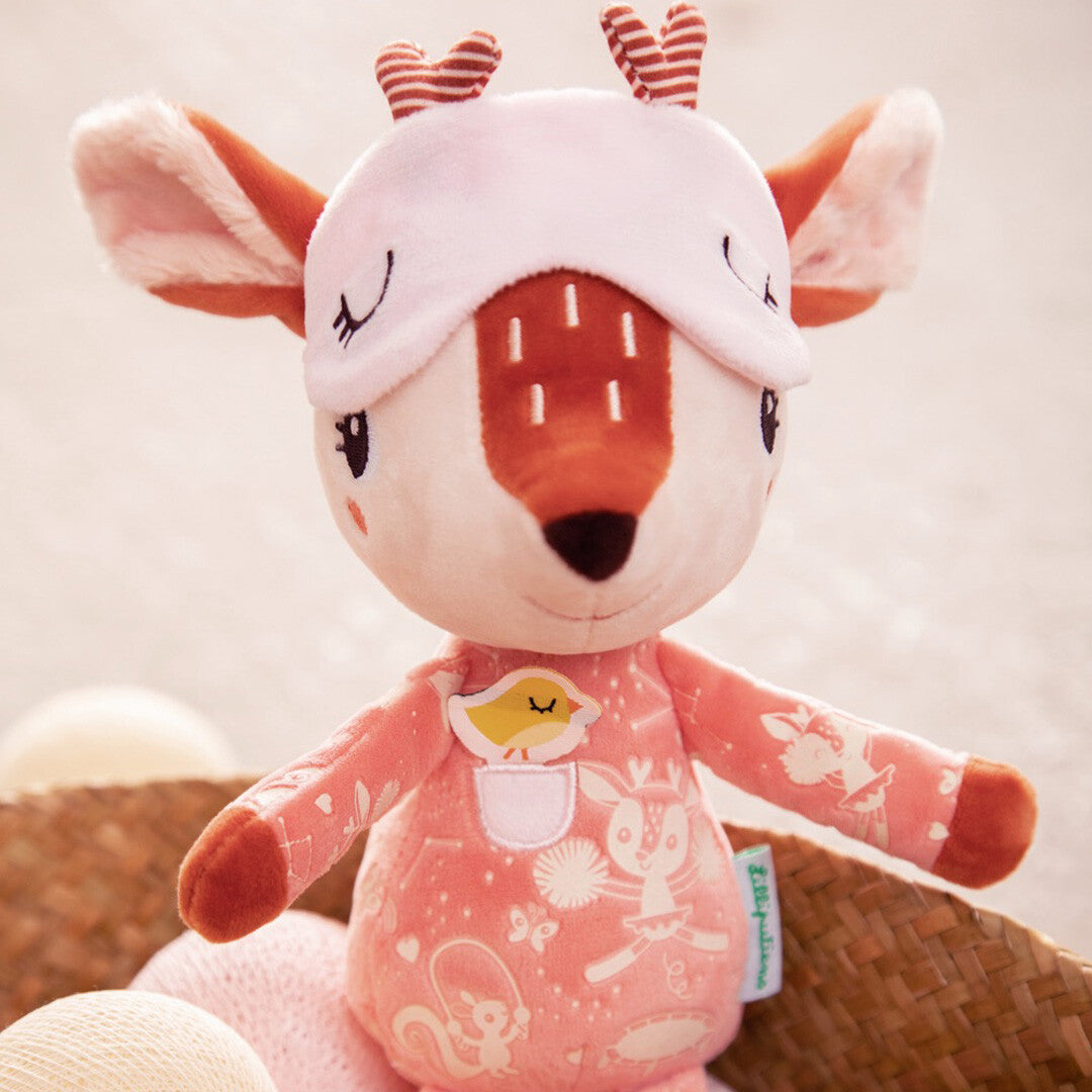 Lilliputiens pluchen knuffel hertje Stella met slaapmasker in een mand met zachte ballen.