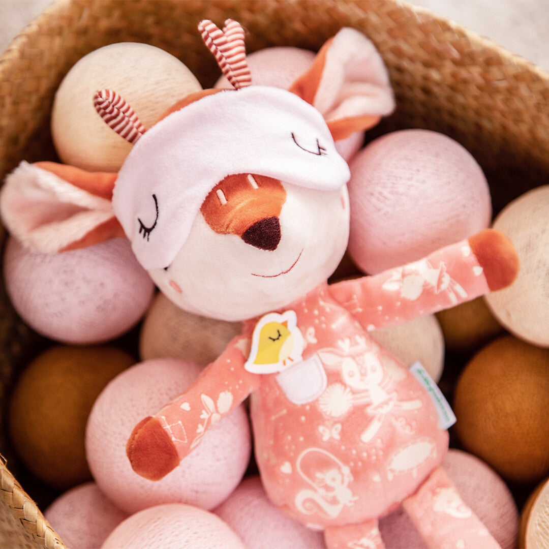 Lilliputiens pluchen knuffel hertje Stella met slaapmasker, liggend in een mand vol zachte ballen.