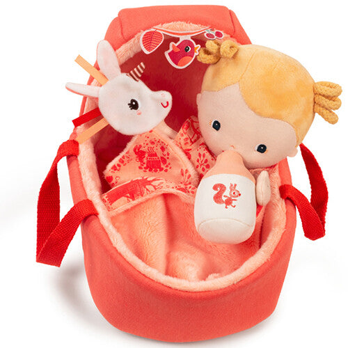 Lilliputiens lappenpop baby Lena ligt met haar flesje en eenhoorn knuffeltje in de oranje draagmand.