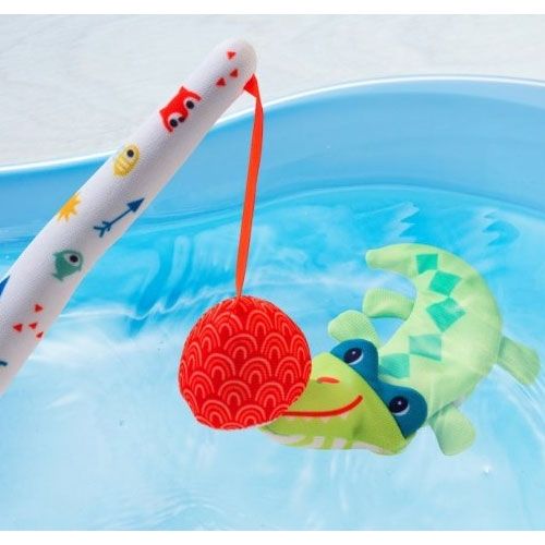 De hengel van het Lilliputiens badspeelgoed visspel vangt een groene krokodil in een blauwe badkuip met water.