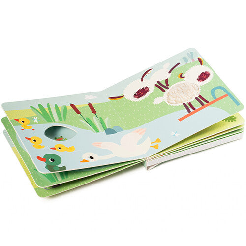 Een open Lilliputiens voelboek met geluiden toont eenden in een vijver en schapen met voelbare texturen.