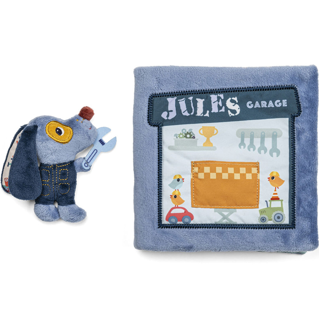Lilliputiens stoffen activiteitsspeelboek gesloten naast de losse pluchen Jules de hond.