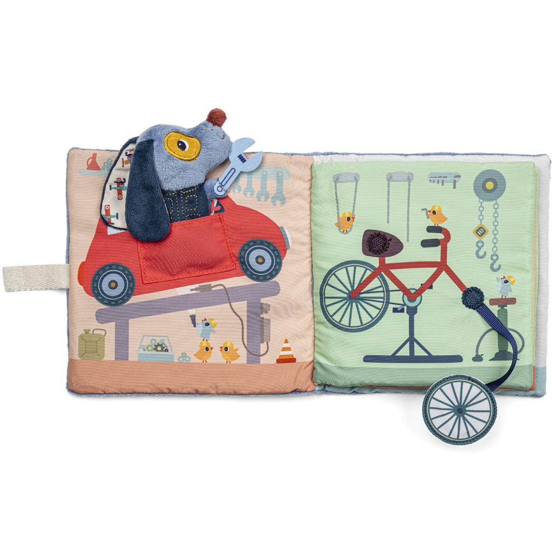 Lilliputiens stoffen activiteitsspeelboek open, met Jules de hond in een rode auto en een fiets op de pagina's.