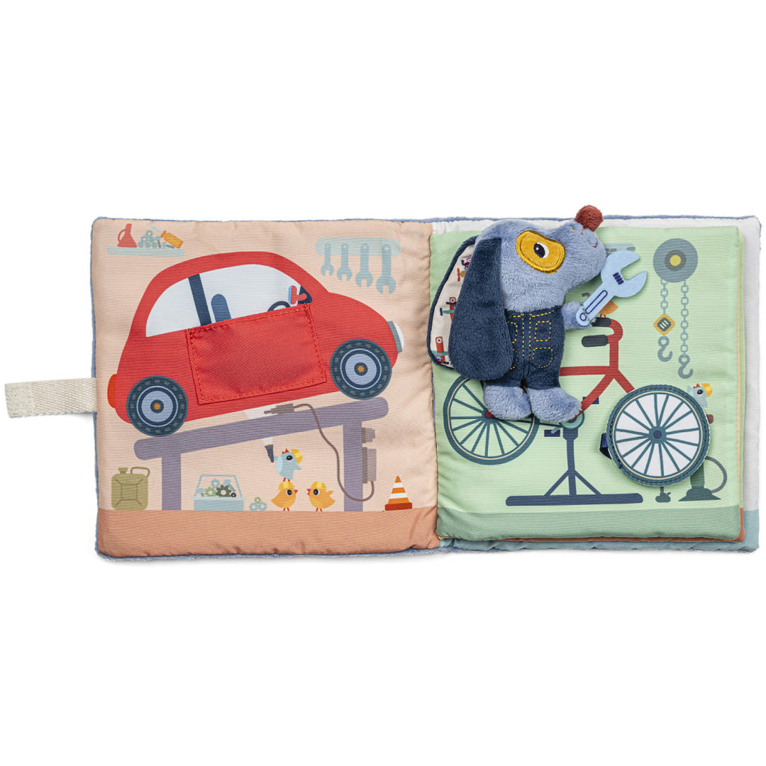 Lilliputiens stoffen activiteitsspeelboek open, met een rode auto en Jules de hond naast een fiets op de pagina's.