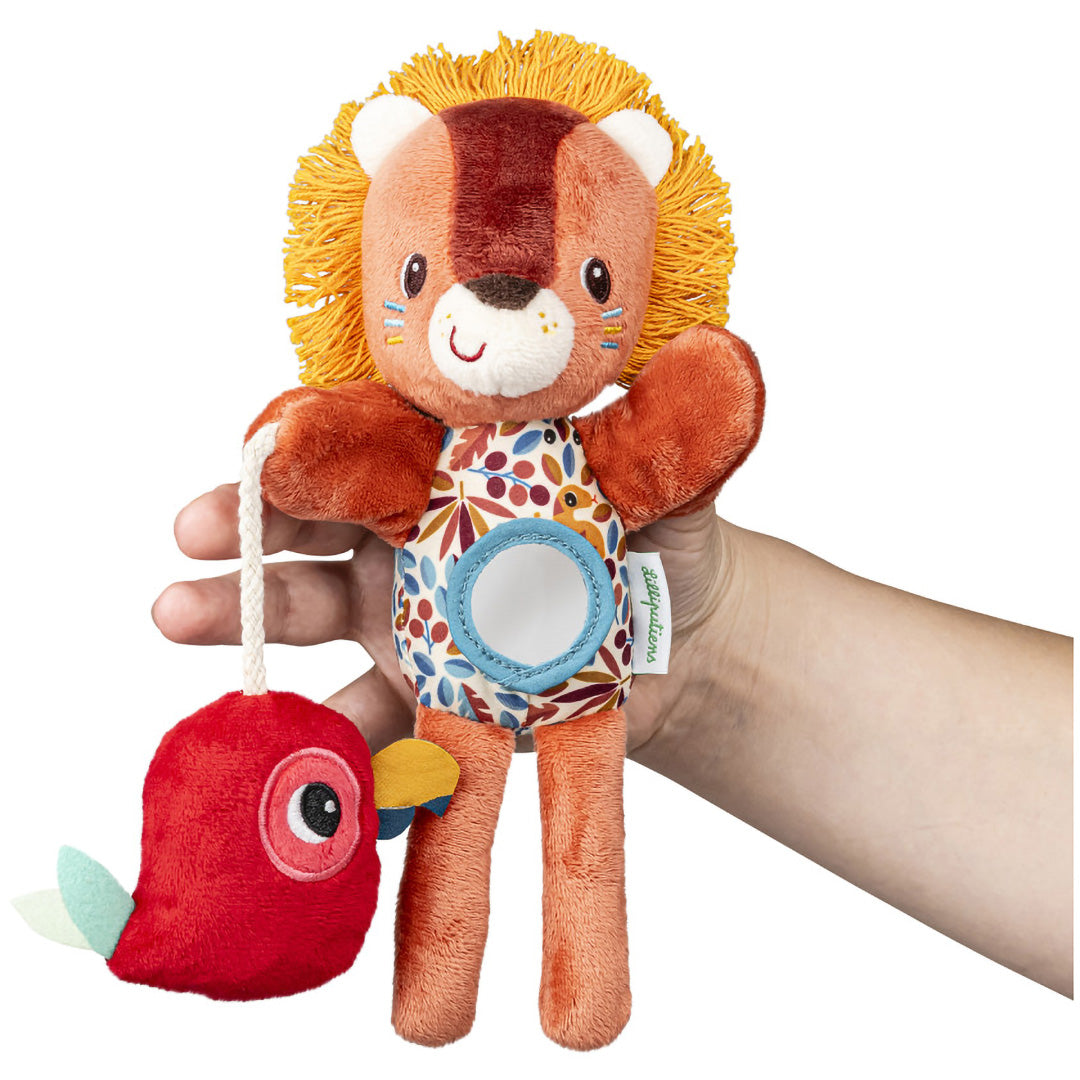 Een hand houdt de Lilliputiens activiteiten handpop van een pluche leeuw met een rode papegaai vast.