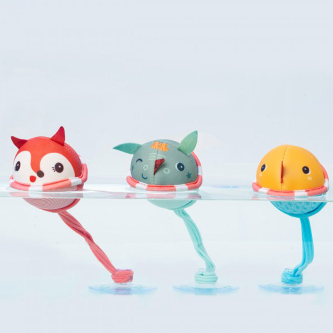 Drie Lilliputiens badballen met zuignap in de vorm van een kip, walvis en vos drijven in water.