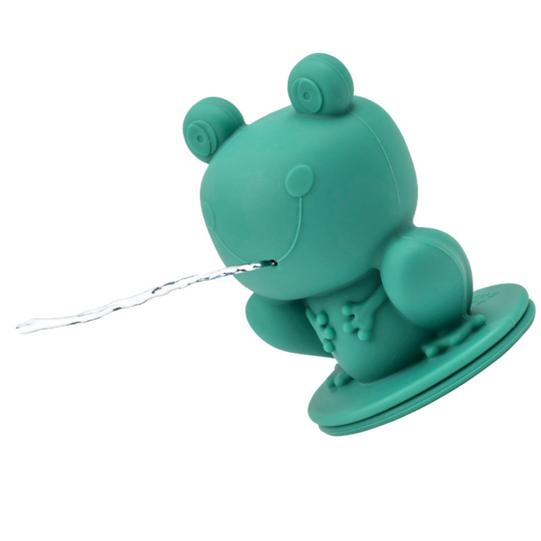 Een groene Lilliputiens badkikker spuit een straal water uit zijn mond.