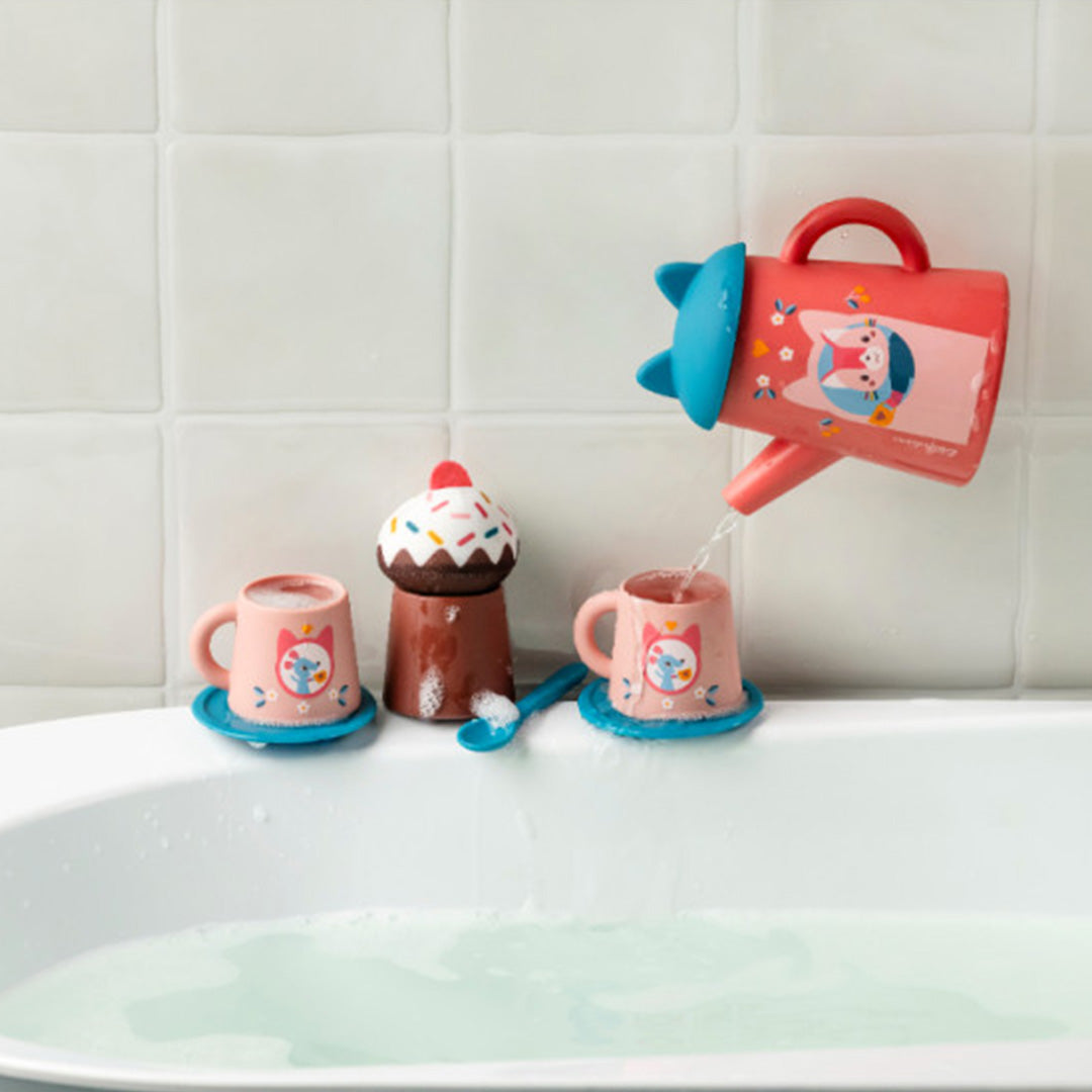 De Lilliputiens badspeelgoed theeset in een badkuip, waarbij de roze theepot water in een kopje met kattenfiguur giet.