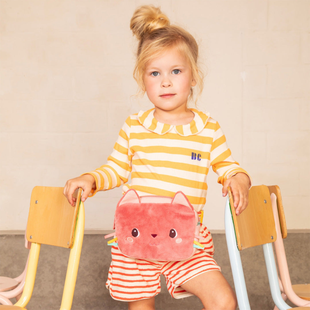 Een jong meisje draagt het roze lilliputiens kindertasje met kattengezicht als heuptasje.