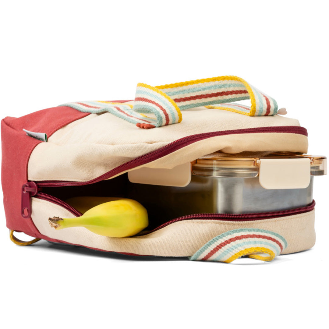De Lilliputiens kleuterrugzak ligt open met een banaan en een lunchbox in het onderste vak.