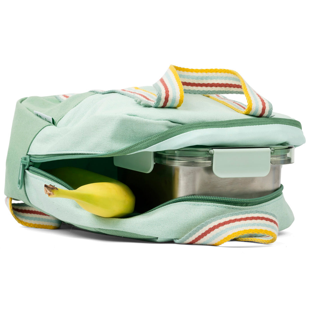 De Lilliputiens kleuterrugzak ligt open en toont een banaan en een lunchbox in het hoofdvak.