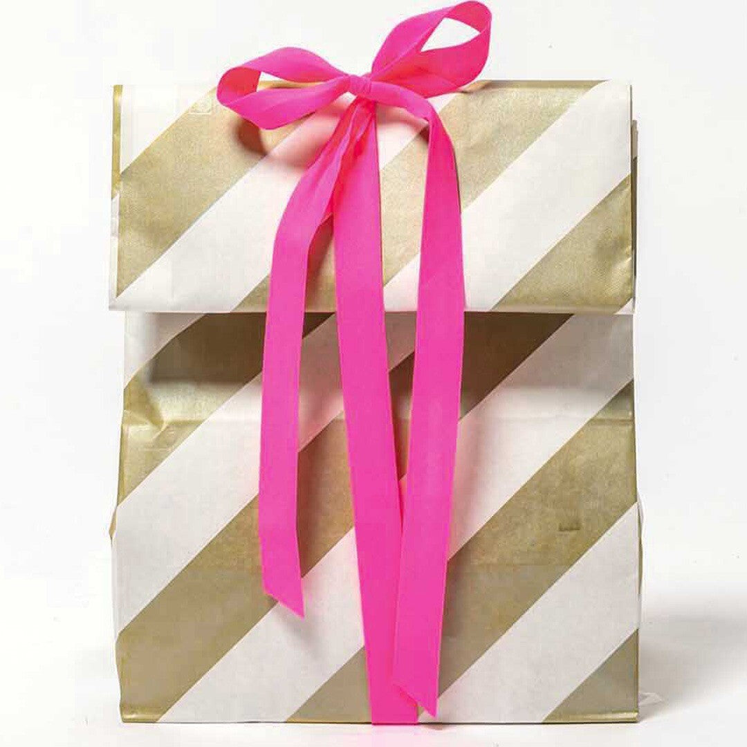 Geschenkverpakking met goud-wit gestreepte zak en een strik van roze lint.