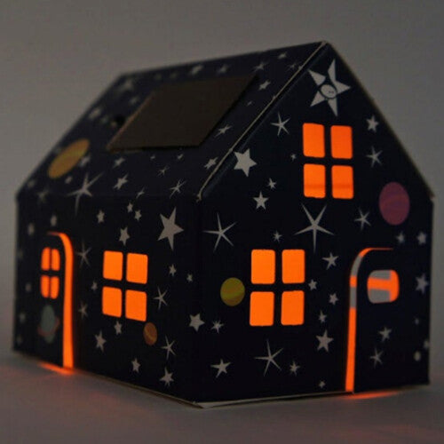 Het Litogami bouwpakketje huisje met sterrenpatroon in het donker, waarbij de ramen en deuren oranje oplichten.