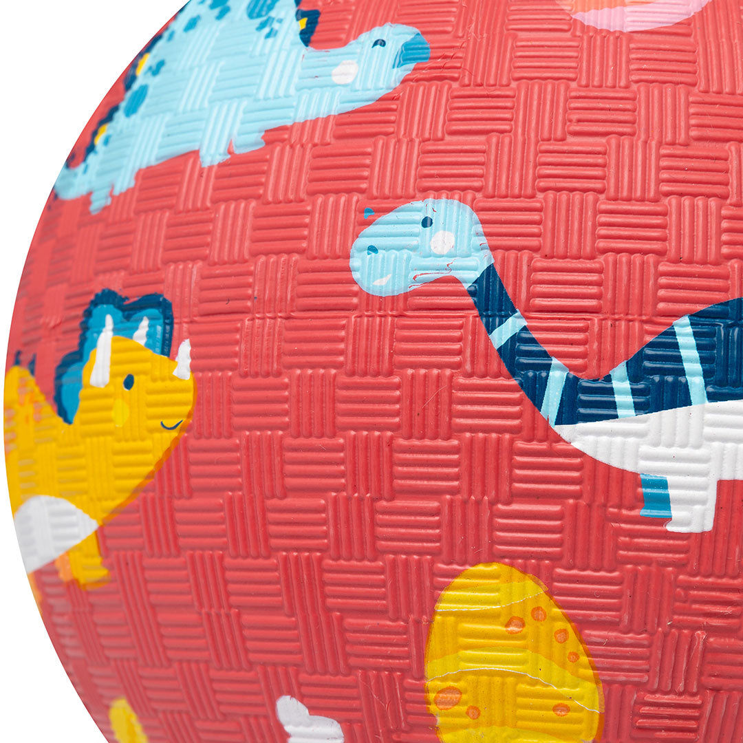 Detail van de rode speelbal met een blauwe dinosaurus en een gele triceratops.