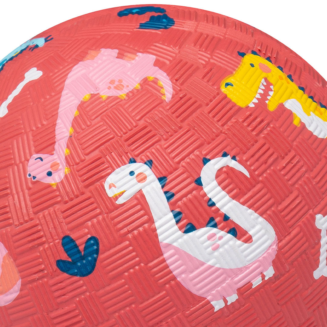 Detail van de rode speelbal met een roze en een witte dinosaurus.