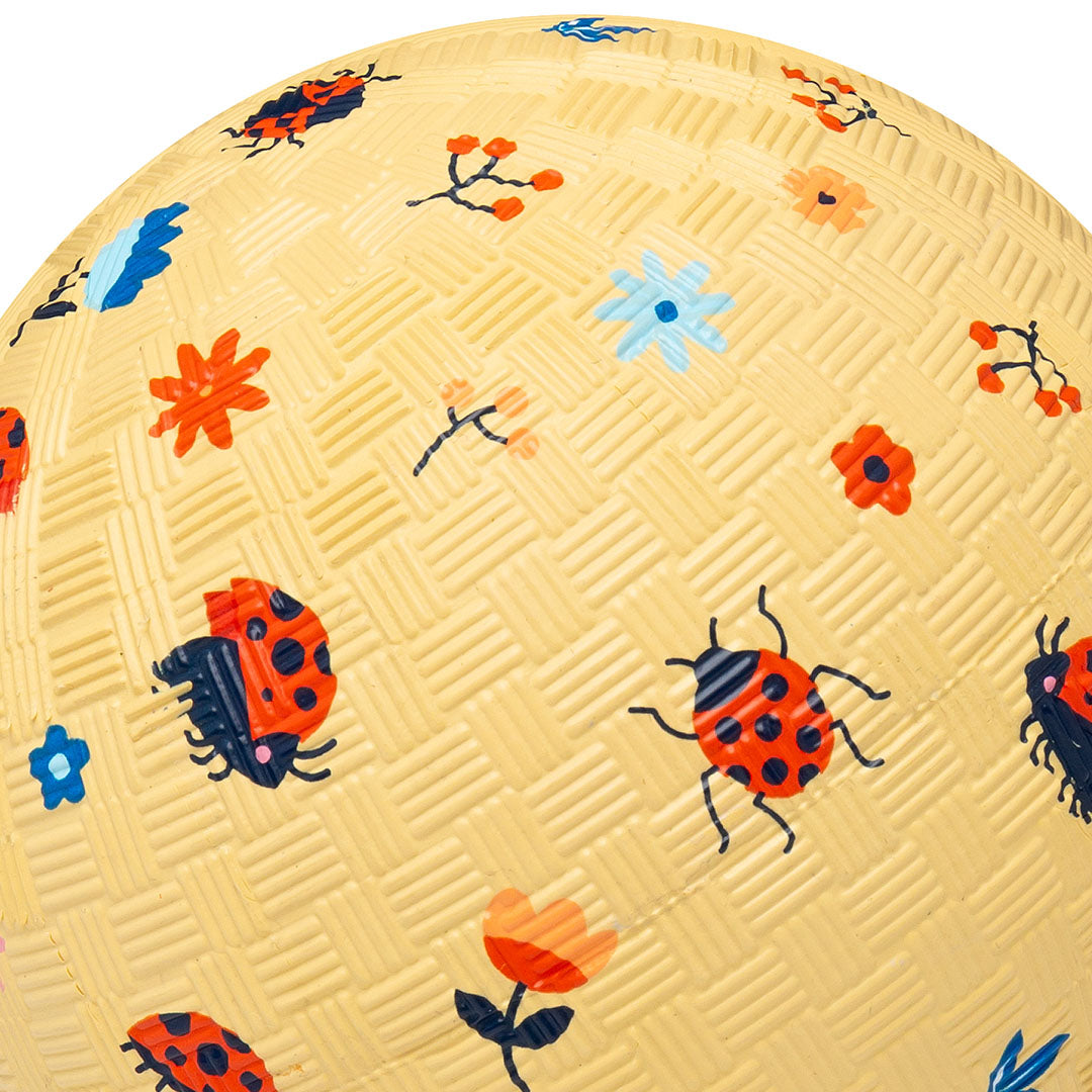 Close-up van de little l speelbal met lieveheersbeestjes en bloemenpatroon.