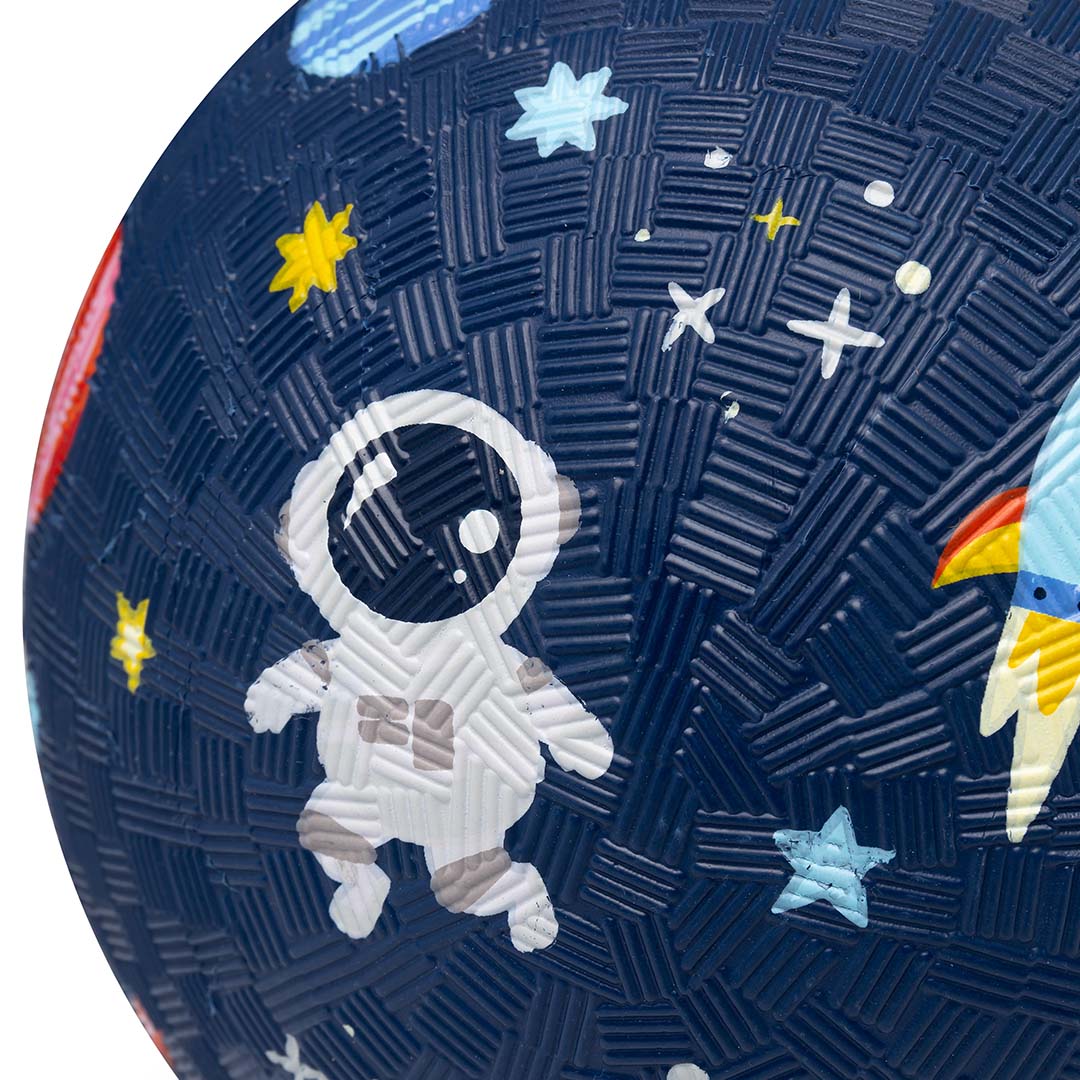 Detail van een blauwe speelbal met een astronaut en sterren op de textuur.