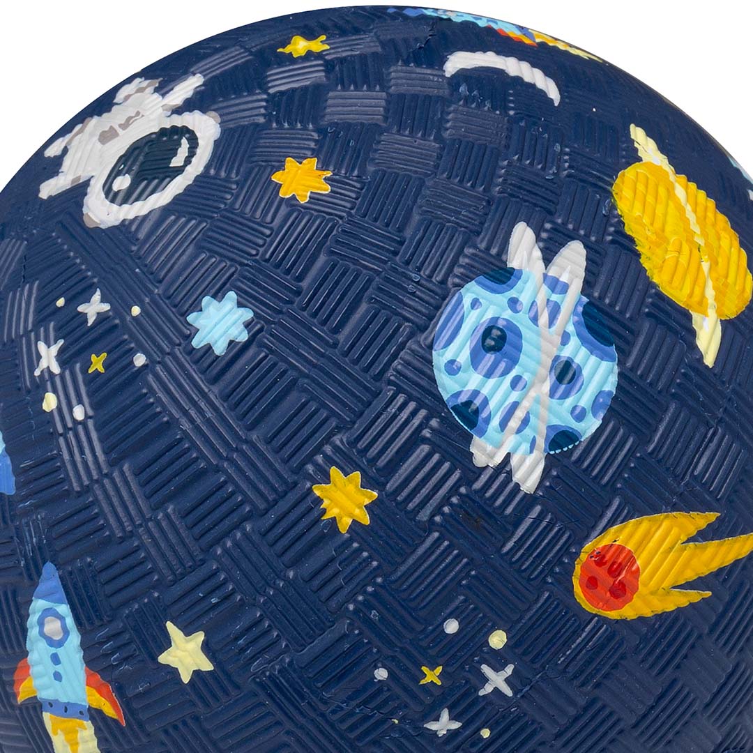 Detail van een blauwe speelbal met een planeet, komeet en sterren op de textuur.