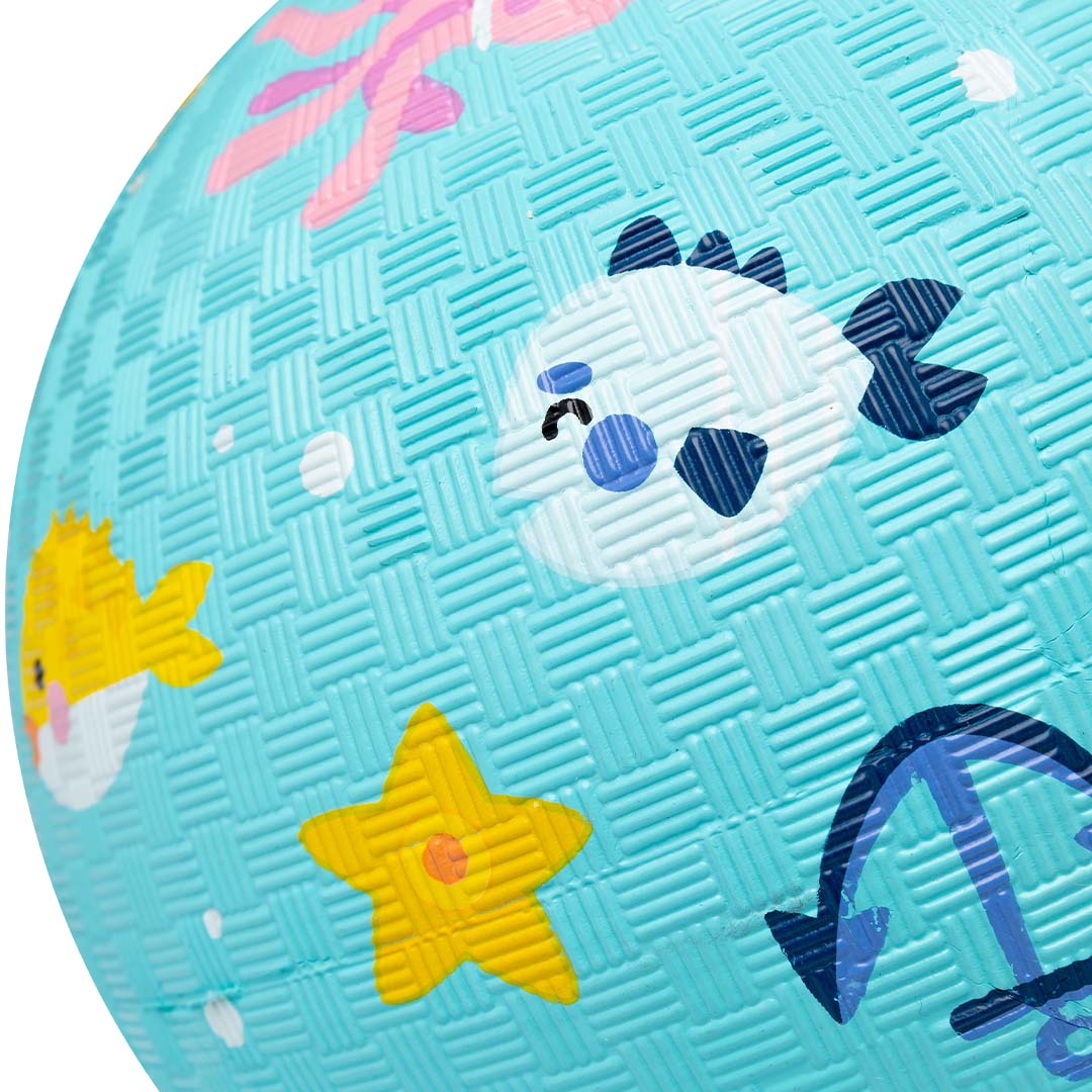Detail van de blauwe speelbal met textuur en een witte vis en gele zeester.