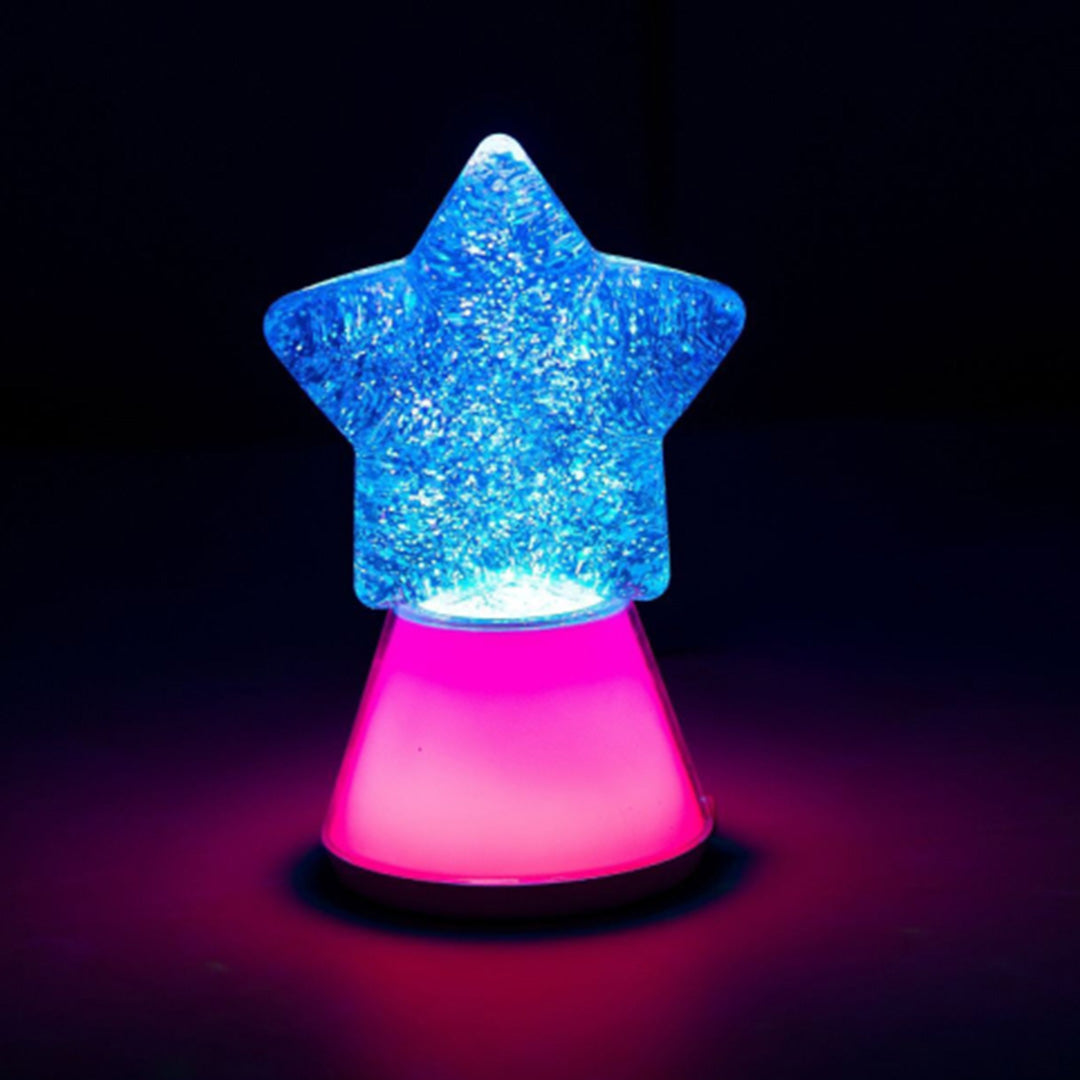Het Little L ster nachtlampje verlicht de kamer met blauw en roze licht.