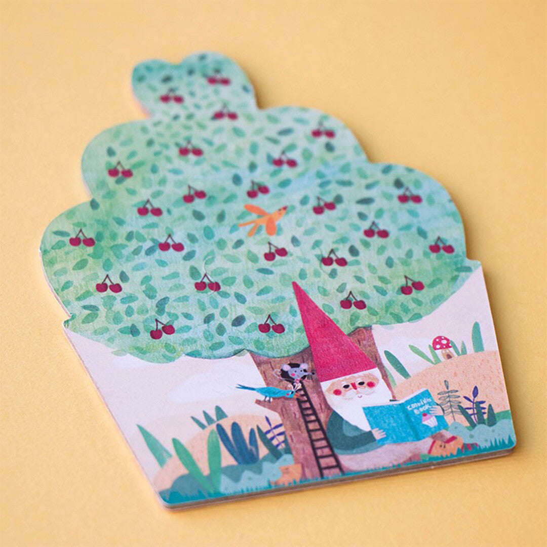Detail van een londji legpuzzelstuk in de vorm van een cupcake met een kabouter onder een kersenboom.
