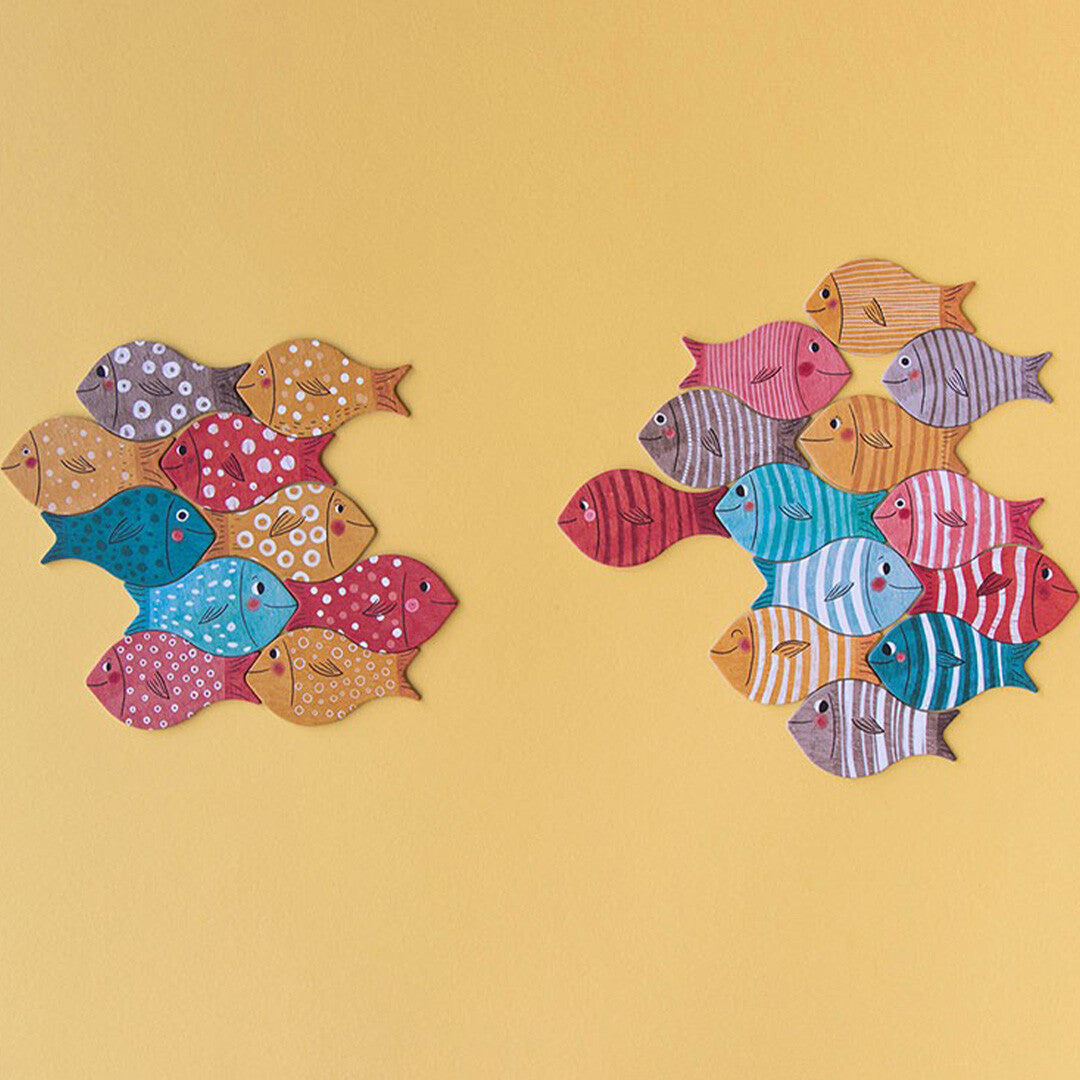 Twee groepen van kleurrijke visjes, de puzzelstukjes, bij elkaar gelegd op een gele achtergrond.