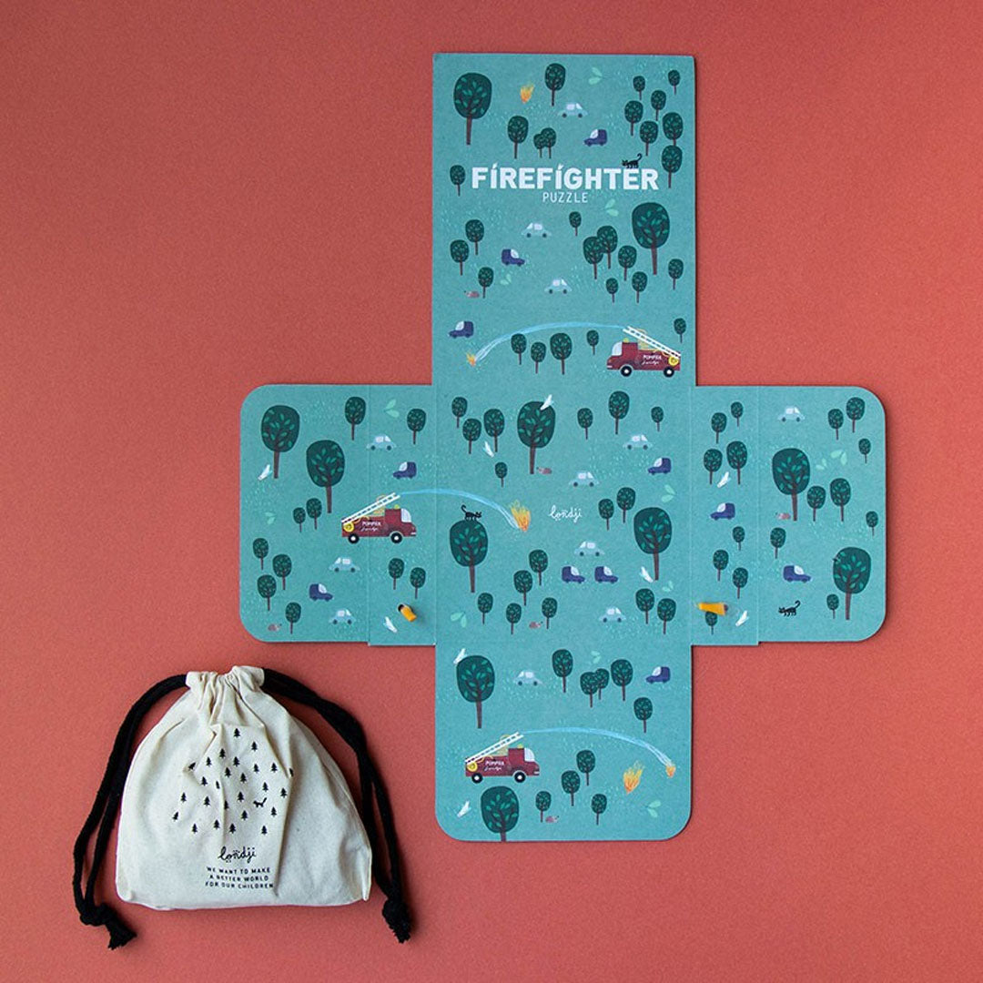 De Londji 'Firefighter' legpuzzelverpakking uitgevouwen naast een stoffen zakje met bomenprint.