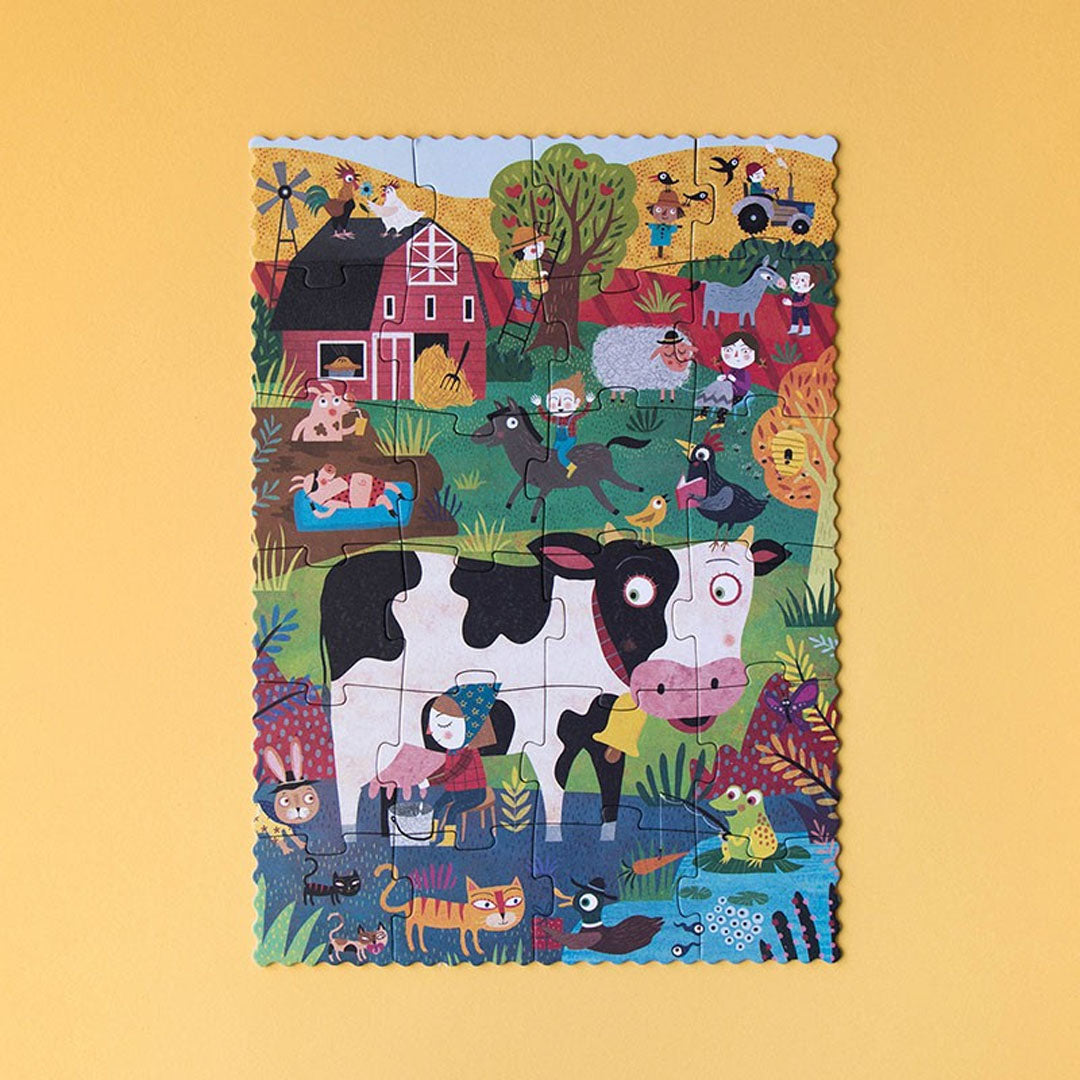 De complete 24-delige boerderij legpuzzel met een koe, boer en andere dieren op een gele achtergrond.