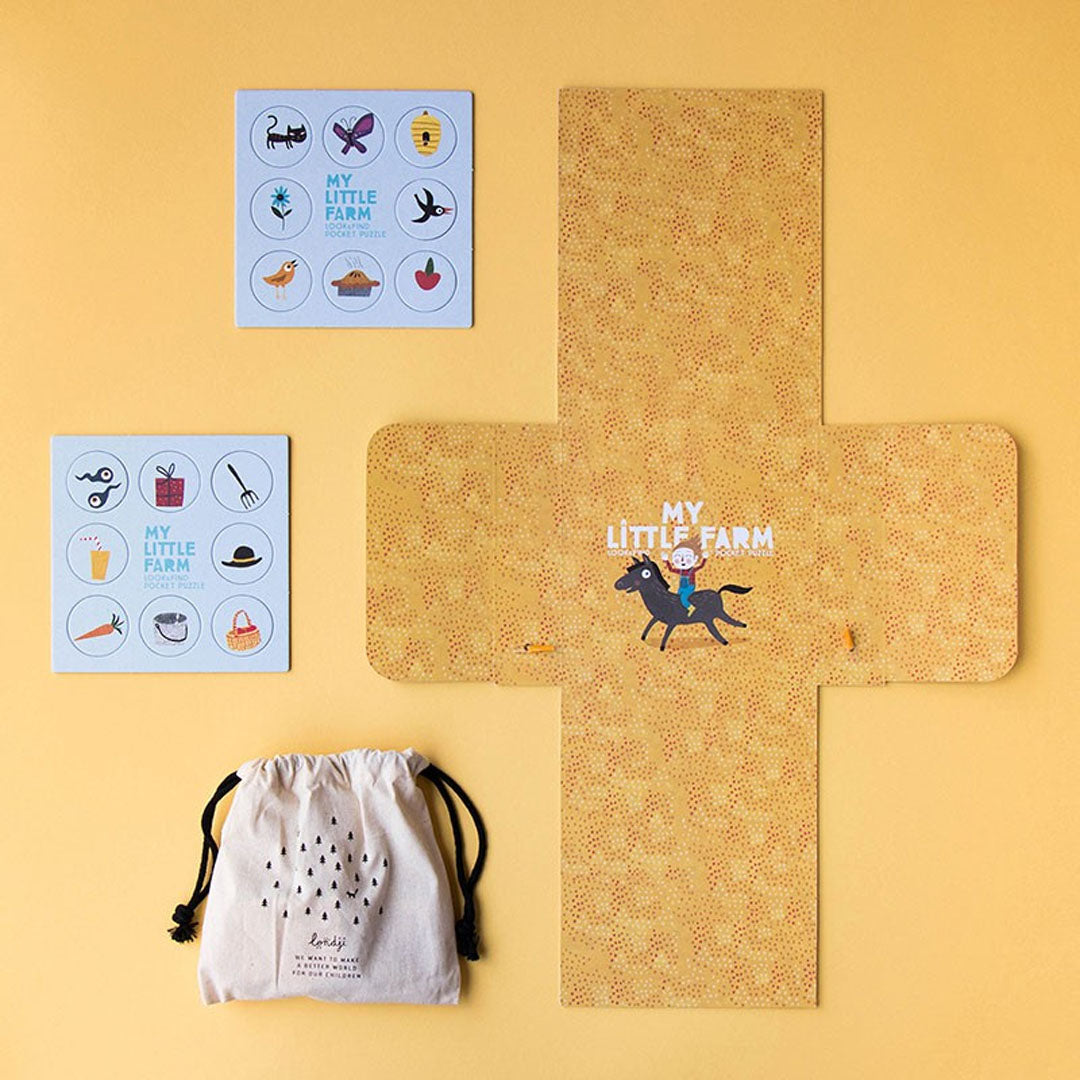 De losse onderdelen van de londji My Little Farm zoekpuzzel, waaronder zoekkaarten, een speelmat en een stoffen zakje.