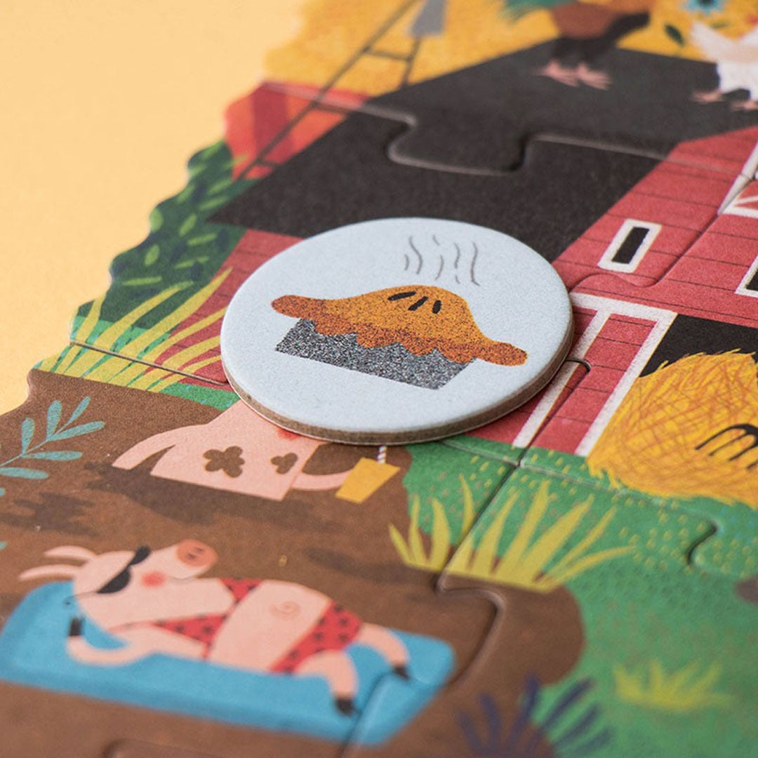 Detail van de boerderij legpuzzel met een varken in een zwembad en een ronde zoekfiche met een taart.