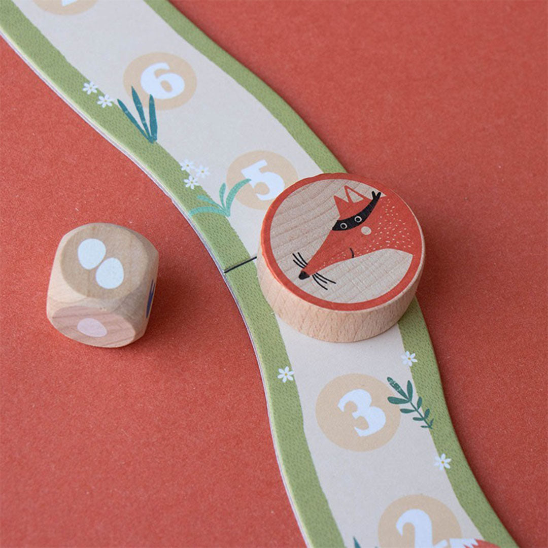 Detail van de genummerde weg op het londji bordspel met een houten dobbelsteen en de vos-token.