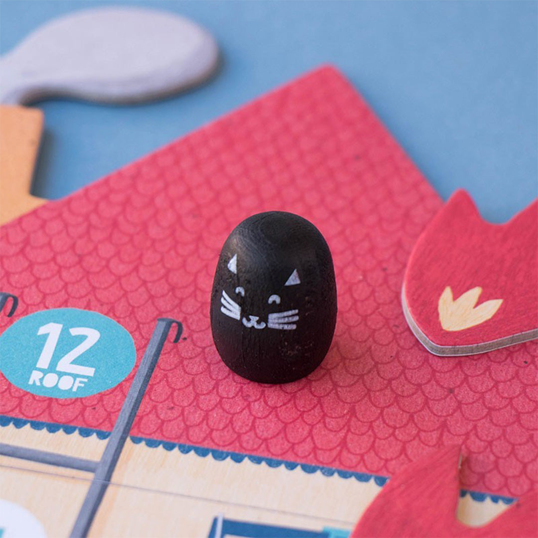 Detail van het londji bordspel met een zwarte kat pion op een rood dak van het speelbord.